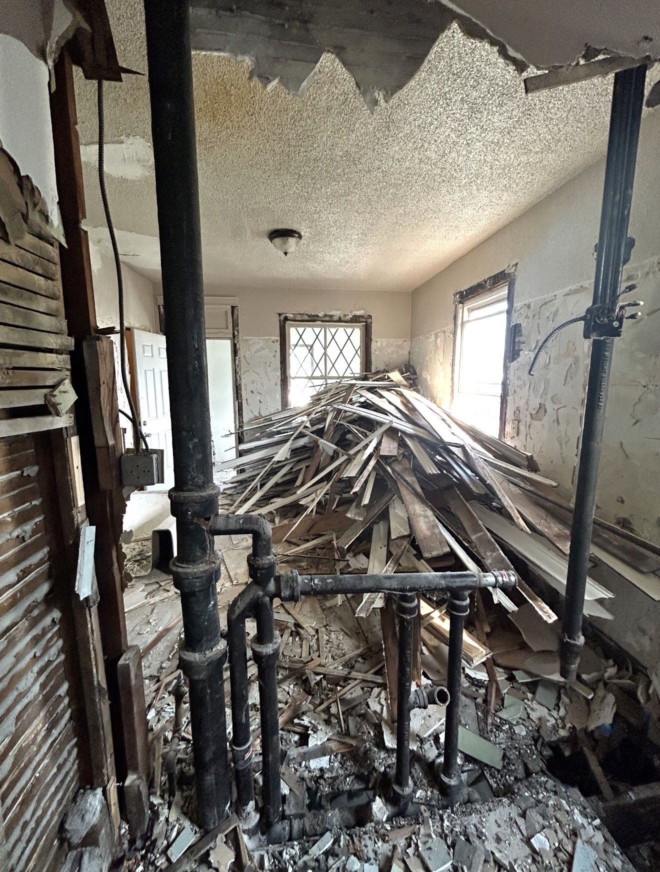 Interior space filled with a large pile of demolition debris before removal