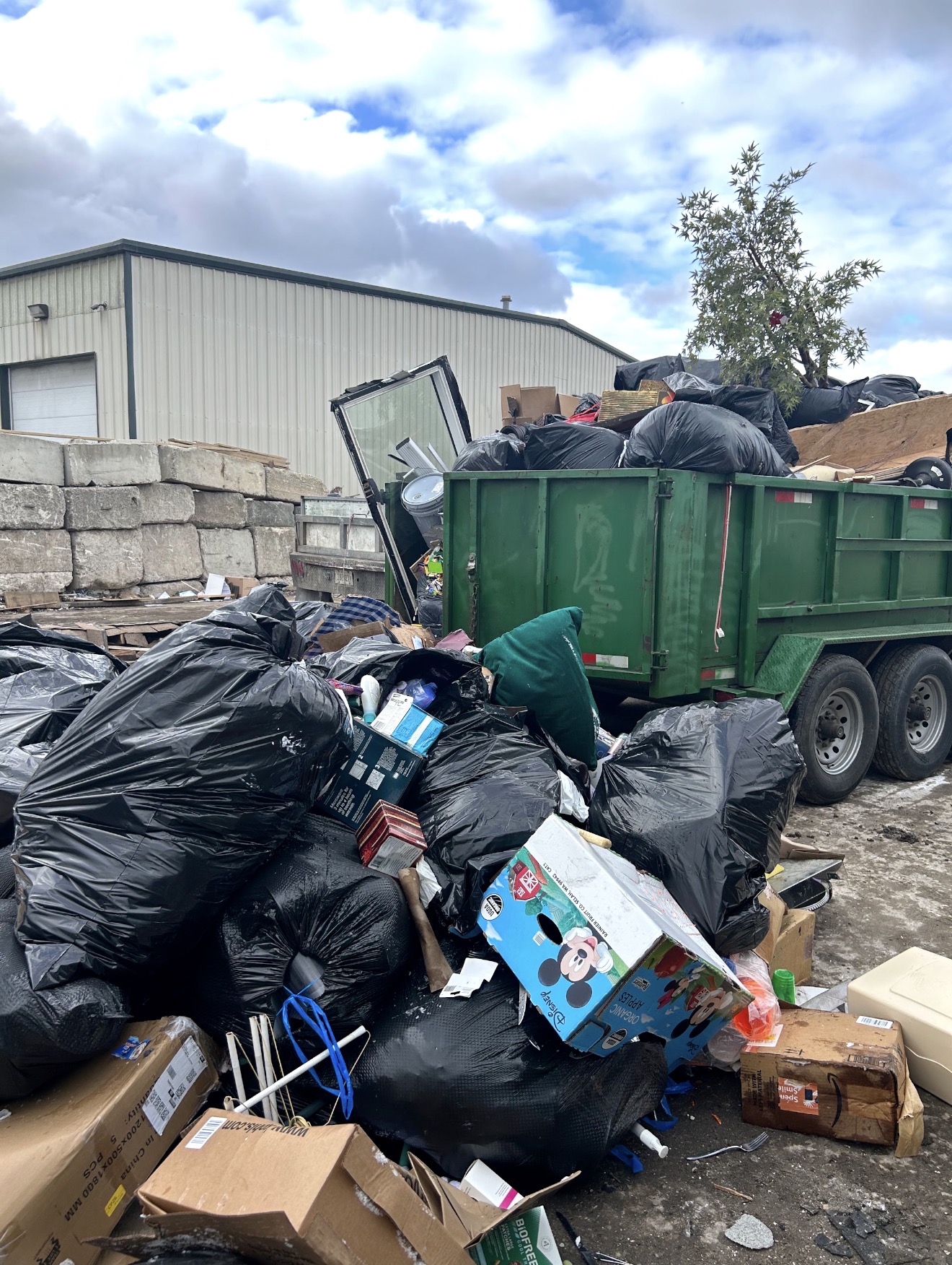 Rigor Contracting dump trailer and bagged debris ready for disposal